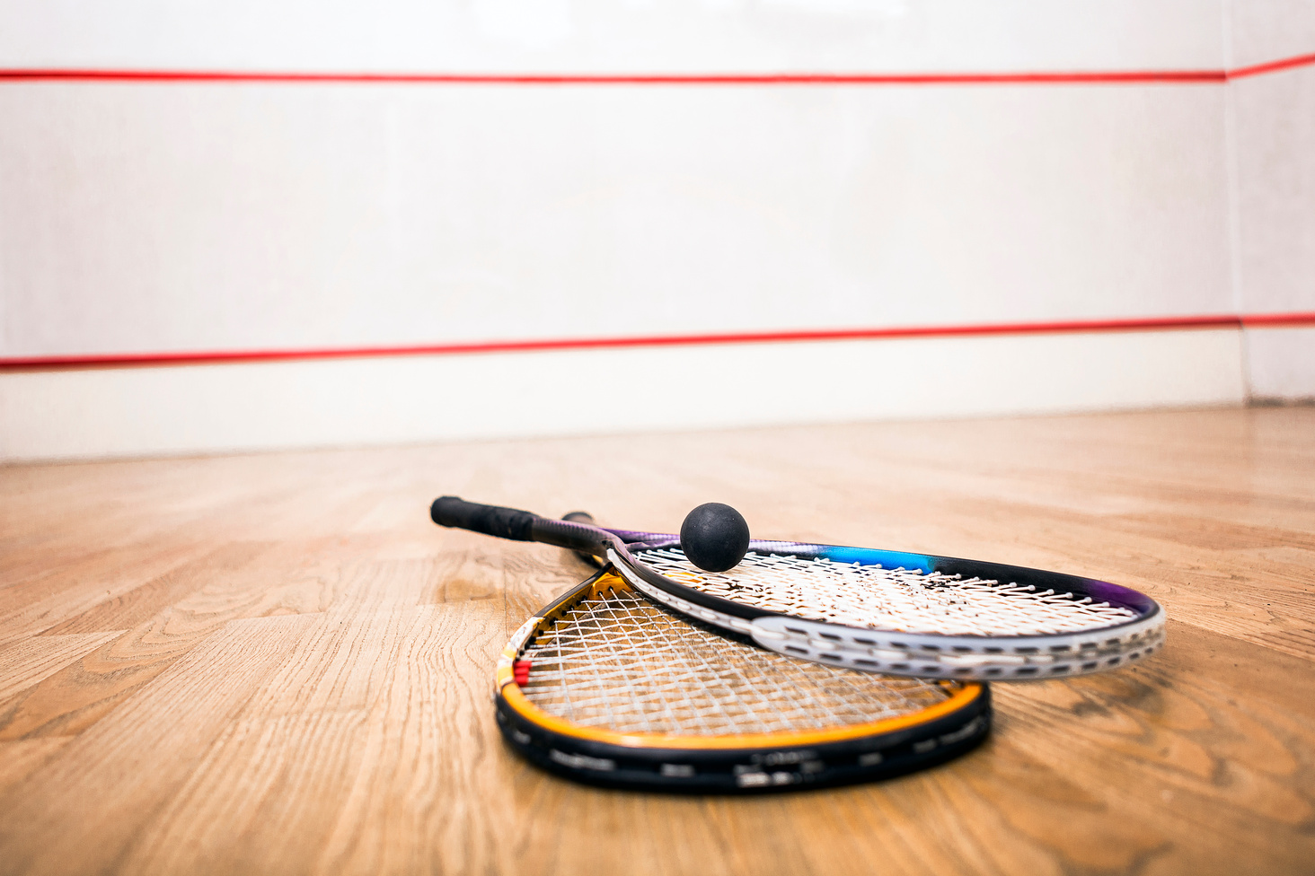 Squash racket and ball on the court close up